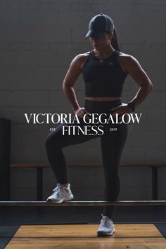 a woman in black sports bra top and leggings standing on a wooden floor