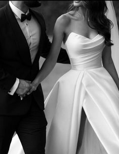 a bride and groom holding hands in black and white