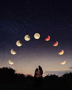 two people are standing in front of the night sky and looking at the moon phases