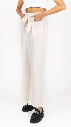 DETAILS Our Self Tie Wide Leg Pants are the perfect choice for a summer day. The light and breezy material are easy to wear, while the tie waist and wide leg design make these pants both stylish and comfortable. The tiered design is perfect for adding a touch of style to any look. Whether you're dressing up for a special occasion or simply looking for a chic choice for everyday wear, these pants are a must-have in your wardrobe. MEASUREMENTS Inseam: 32" Leg Opening 23 1/2" COMPOSITION & CARE 55% White Tie-side Bottom Pants For Summer, Chic Summer Bottoms With Drawstring Tie, Wide Leg Pants With Pockets For Beach Season, White Pants With Elastic Waistband And Tie-side, White Tie-side Bottom Pants For Spring, Spring Vacation Bottoms With Drawstring Tie, Summer Wide Leg Pants With Pockets, Vacation Trousers With Tie Waist, Cream Wide Leg Beach Bottoms