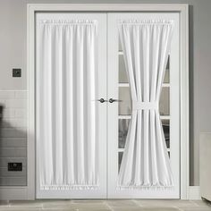 a white door with curtains on it in a room