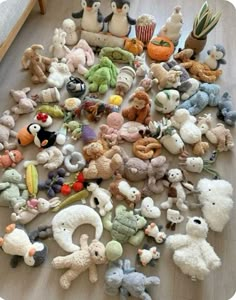 a pile of stuffed animals sitting on top of a wooden floor