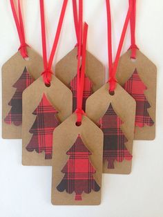 four tags with christmas trees on them hanging from red string