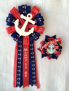 a red, white and blue ribbon with an anchor on it next to a brooch