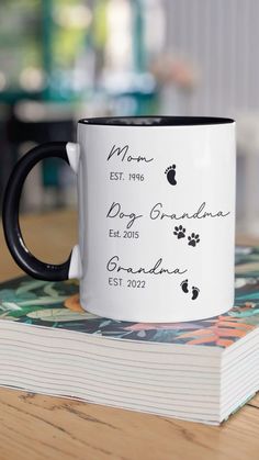 a black and white coffee mug sitting on top of a table next to a stack of books