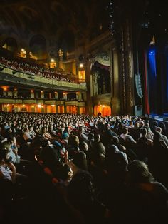 an auditorium full of people sitting and standing