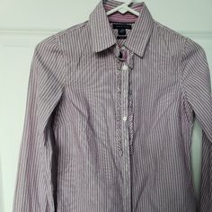 Tommy Hilfiger Ruffled Placket Striped Button Up Fitted Purple Shirt Blouse Size 2. Lightweight 100% Cotton Purple And White Striped Fabric. Collared Neck. Ruffle Detail Along Button Closure. Contrasting Velvet Ribbon Under Buttons. Fitted Button Down Shirt. Long Cuffed Sleeves. Rounded Hemline. See Photos For Measurements. New With Tags. Comes From Clean Pet And Smoke Free Home. Preppy Buttoned Tops For Work, Formal Ruffled Button-up Shirt, Tommy Hilfiger Long Sleeve Work Shirt, Tommy Hilfiger Long Sleeve Shirt For Work, Preppy Fitted Button-up Blouse, Fitted Button-up Preppy Blouse, Tommy Hilfiger Button-up Shirt For Spring, Tommy Hilfiger Button-up Tops, Tommy Hilfiger Long Sleeve Blouse