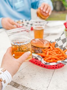 two people sitting at a table with food and drinks