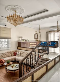 a living room filled with lots of furniture and a chandelier hanging from the ceiling