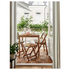 an open door leading to a small balcony with plants on the table and two chairs