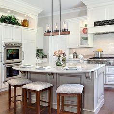 a kitchen with an island and stools next to the stove, oven and microwave