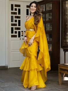 Introducing our glamorous yellow organza ready-to-wear ruffle saree with blouse! This stunning ensemble is crafted from high-quality organza material in a beautiful yellow color. The saree is stitched in layers, creating a chic and fashionable look that is sure to turn heads.
One of the key features of this saree is the golden color organza material sleeveless blouse. It is adorned with intricate sequin work, adding a touch of glamour and sophistication. The sequins sparkle and shimmer as they c Traditional Yellow Ruffled Sharara, Elegant Yellow Pre-draped Saree For Party, Yellow Fitted Organza Pre-draped Saree, Bollywood Style Floor-length Saree With Ruffles, Bollywood Style Floor-length Ruffled Saree, Festive Yellow Ruffled Sharara, Party Yellow Organza Pre-draped Saree, Yellow Ruffled Wedding Sets, Floor-length Ruffled Dupatta For Party