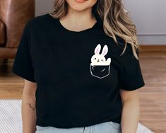 Pocket Bunny Shirt, Funny Easter Tee, Minimal Easter Tee, Pocket Size Rabbit, Easter T-Shirts, Bunny Lover Shirt, Easter Bunny Tee, Cute Top Welcome to VickyTeeDesign Shop! How to Order * Please choose your t-shirt color and the shirt size by the drop-down menus * Enter the design idea or the personalization if you would like. * Please feel free to ask any questions. My Shirt Material Is Below: Solid colors: %100 Cotton. (White and Black) Heather colors: %52 Cotton + %48 Polyester. Please Consid Bunny Tshirt Ideas, Cute Black Crew Neck Shirt, Cute Black Shirt For Spring, Minimal Easter, Easter Tees, Funny Easter, My Shirt, Rabbit Easter, Easter T Shirts