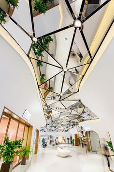 the interior of an office building with plants and mirrors on the ceiling