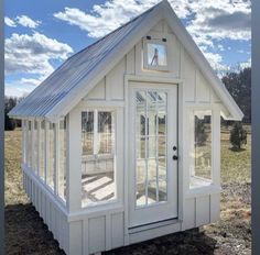 a small white building with windows on the roof