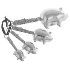 three silver pig figurines are hanging from a key chain on a white background