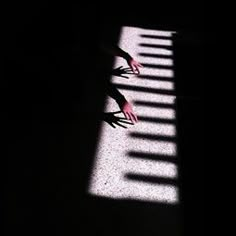 the shadow of a person's hand on a piano keyboard with words written below it