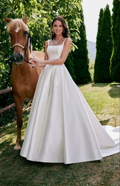 a woman standing next to a brown horse