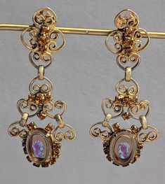 "Vintage 1960s era signed Celebrity by Juliana statement earrings. These are such beautiful and ornate earrings. Earrings feature glass cameos prong set in filigree goldtone with citrine rhinestones also prong set. Earrings are clip back style. Earrings are fully hallmarked and will arrive gift boxed. MARKS Celebrity on clip backs. CONDITION In very good to excellent condition. Please use all pictures as part of item's description. SIZE  2 7/8\" x 1 1/4\". MATERIALS Glass, Goldtone, Rhinestones. Antique Chandelier Earrings For Formal Occasions, Victorian Dangle Chandelier Earrings For Parties, Victorian Chandelier Dangle Earrings For Party, Victorian Style Party Chandelier Earrings, Vintage Gold Clip-on Earrings For Vintage Events, Gold Vintage Clip-on Earrings For Vintage Events, Gold Vintage Clip-on Earrings, Victorian Chandelier Drop Earrings For Evening, Victorian Chandelier Earrings For Evening