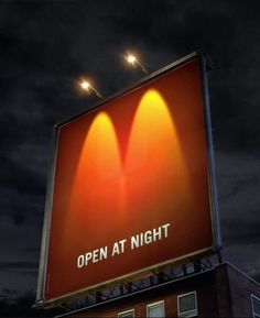 an open at night sign on top of a building