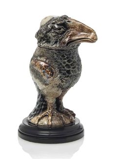 a silver and black bird figurine sitting on top of a table