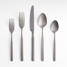 four forks, two spoons and one knife on a white surface