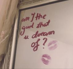 a mirror with some writing on it and two pink lips drawn on the glass next to it