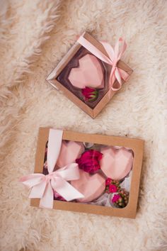 two pink heart shaped cakes in a box on a white furnishing area with a ribbon tied around the top