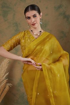 Golden yellow silk organza saree with mirror embroidery. Comes with thread embroidered blouse.
Components: 2
Pattern: Embroidered
Type Of Work: Mirror, Floral
Neckline: V Neck
Sleeve Type: Half
Fabric: Silk organza
Color: Gold,Yellow
Other Details: 
Note: Petticoat worn by the model is not for sale.
Occasion: Wedding - Aza Fashions Diwali Sheer Dupatta Blouse In Dola Silk, Designer Cutdana Organza Blouse, Designer Organza Blouse With Cutdana, Navratri Organza Blouse With Dupatta, Diwali Blouse In Organza With Traditional Drape, Traditional Drape Organza Blouse With Cutdana, Diwali Organza Blouse With Traditional Drape, Traditional Drape Organza Blouse For Diwali, Traditional Organza Blouse For Festive Occasions