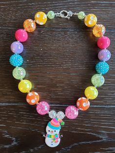 "Rainbow Snowman Chunky Bubblegum Rainbow Bead Necklace & Bracelet This Rainbow Snowman themed necklace will bring a smile to your little one's face! Great accessory to put with any color of the rainbow. This will make a lovely party favor, holiday party accessory or gift for birthdays or holidays. Made with primarily 20mm bubblegum beads in shades of pink, orange, yellow, green, blue and purple. The necklace measures approximately 11\" when toggled around neck including the unicorn pendant. Sofia Amulet, Holiday Party Accessories, Disney Bracelet, Unicorn Pendant, Chunky Bead Necklaces, Bracelet Christmas, Pink Orange Yellow, Bubblegum Beads, Christmas Bracelet