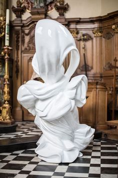 a white sculpture sitting on top of a black and white checkered floor