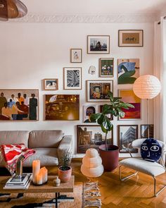 a living room filled with furniture and pictures on the wall