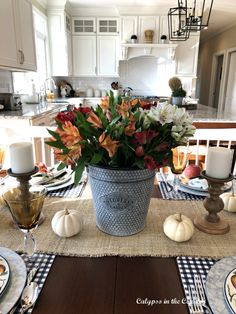 White kitchen with dining table decorated with colorful flowers, galvanized metal and white pumpkins. Casual Thanksgiving Table, Thanksgiving Dinner Table Setting, Thanksgiving Setting, Thanksgiving Table Centerpieces, Fall Dining Room, Thanksgiving Table Setting, Simple Table Settings