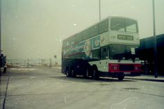 a double decker bus is parked in front of a building on a foggy day