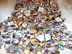 a pile of assorted colored tiles on top of a white table next to a plastic container