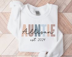 * HOLIDAY ORDER DEADLINE: DEC 9 * (Orders placed after this date may not arrive by Dec 24th.) Personalized Auntie Sweatshirt, Promoted to Aunt Please Note the Following: - A mockup can be sent if requested.  Please add request in the personalization area.  - I can offer custom requests. Please message me before purchasing to inquire. This adult sweatshirt is super soft; size up for a slouchy/oversized look. ITEM OVERVIEW * Gildan 18000 * Unisex crewneck sweatshirt * 50% Cotton, 50% Polyester * R White Sweatshirt With Name Print For Birthday, White Letter Print Sweatshirt For Birthday, White Sweatshirt For Mother's Day, Auntie Things, Birthday Gift For Aunt, Aunt Sweater, Auntie Sweatshirt, Promoted To Aunt, Aunt To Be