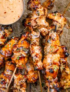 grilled chicken skewers with dipping sauce on the side, ready to be eaten