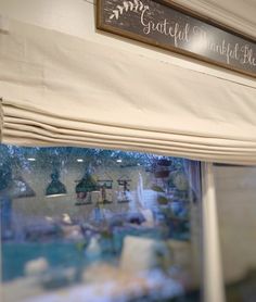 a window with a sign that says grateful and blue sky above the windowsills