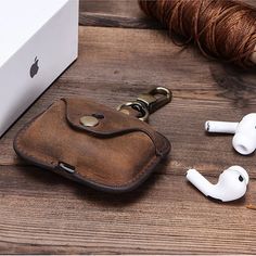 an iphone and ear buds sitting on top of a wooden table next to a box