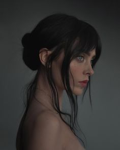 a woman with dark hair and blue eyes is looking off to the side while wearing a black dress