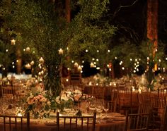 the tables are set with candles and centerpieces for an elegant wedding reception at night