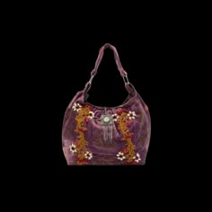 a purple handbag with flowers and beads on the front, sitting against a black background