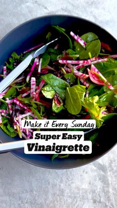 a blue bowl filled with greens and radishes on top of a white table