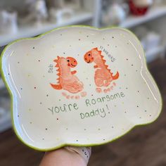 a hand holding a plate with two dinosaurs on it that says, you're awesome today