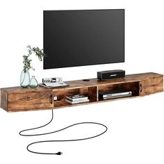 an entertainment center with a flat screen tv mounted on it's side, connected to a cord