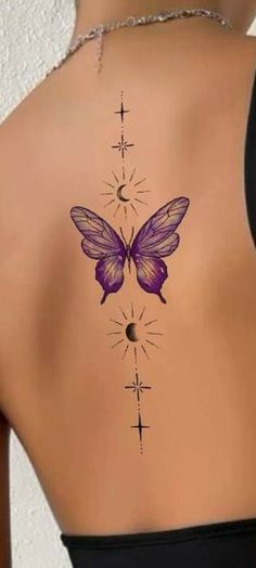 a woman's back with a purple butterfly tattoo on her left shoulder and cross tattoos on the other side