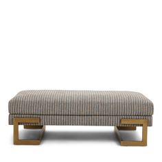 an upholstered footstool with wooden legs and a checkered fabric cover