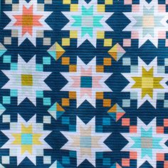 a blue quilt with multicolored stars on it