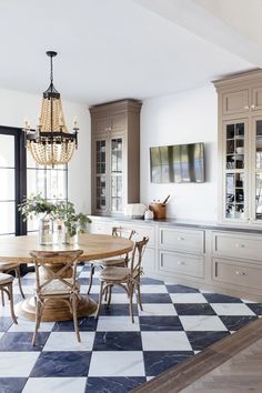 a dining room table with chairs and a chandelier hanging from it's ceiling