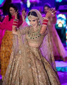 a woman in a bridal gown dancing with other women behind her on the dance floor